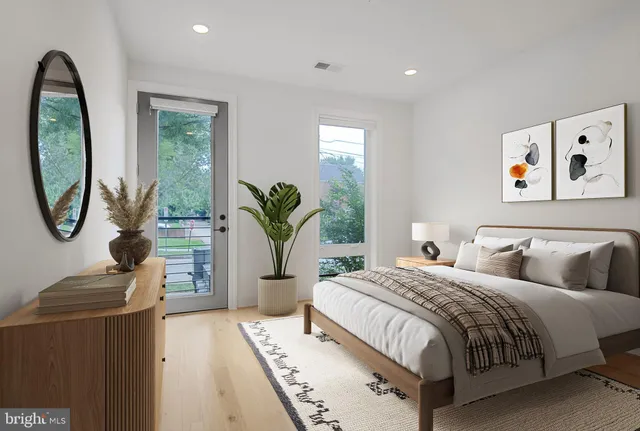 a bedroom with bed and a potted plant next to a window
