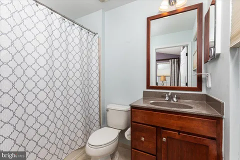 a bathroom with a granite countertop toilet and a sink