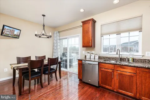 a kitchen with granite countertop wooden floors and wooden cabinets