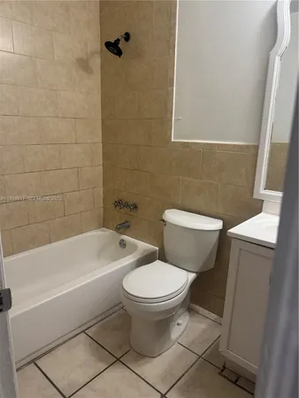 a white toilet sitting next to a bath tub