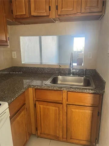 a kitchen with granite countertop a sink and a stove