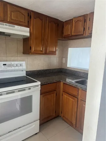 a kitchen with granite countertop cabinets stainless steel appliances and a sink