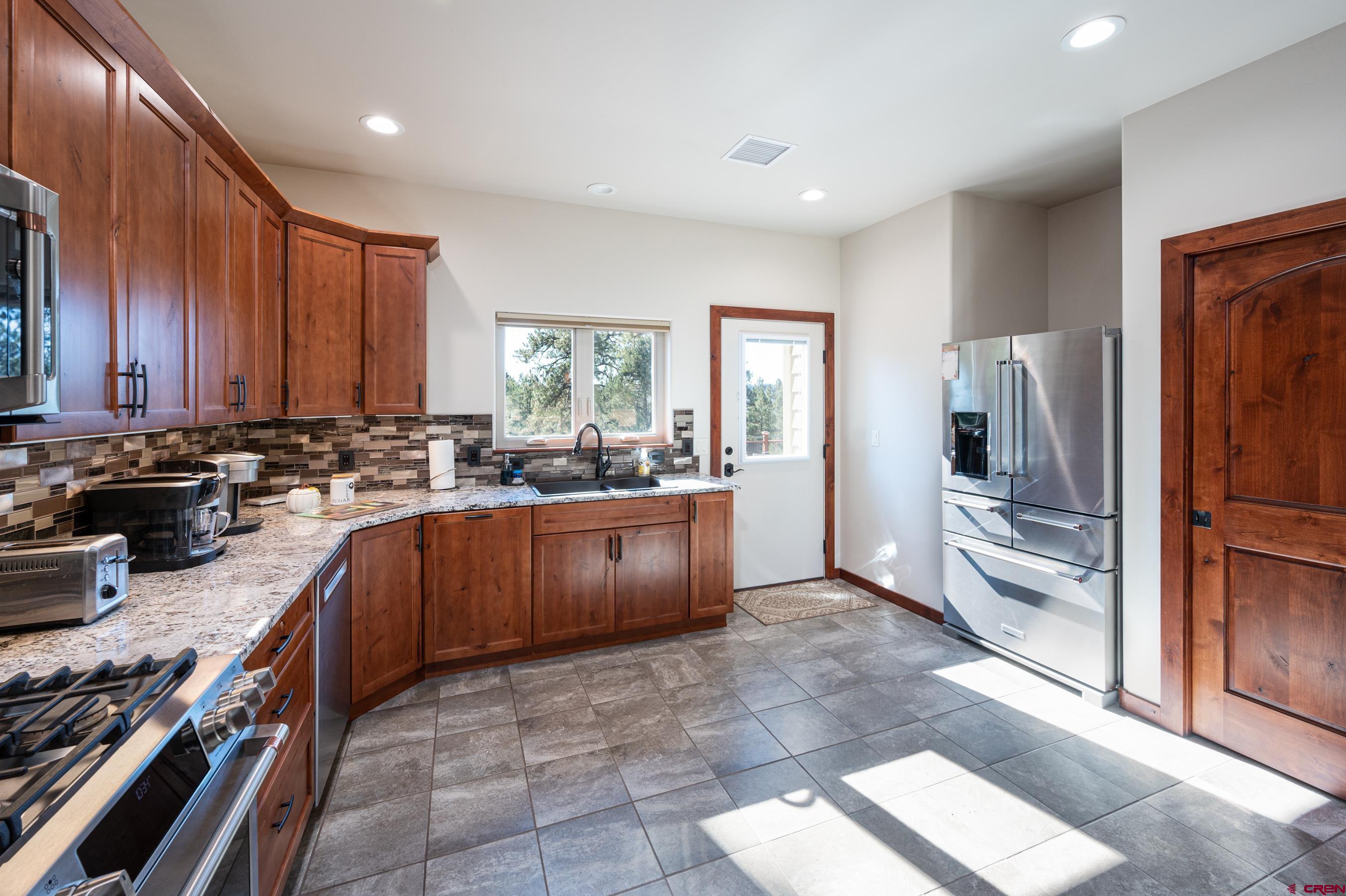 180 Ridge Road Durango, CO 81303 - Photo 10 of 35 a kitchen with granite countertop a refrigerator and a stove top oven