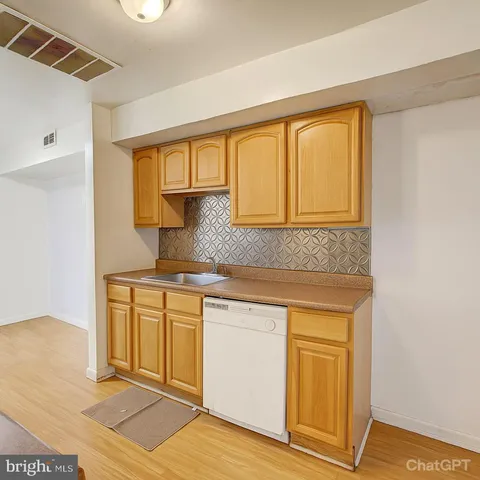 a kitchen with stainless steel appliances granite countertop a sink and cabinets with wooden floor