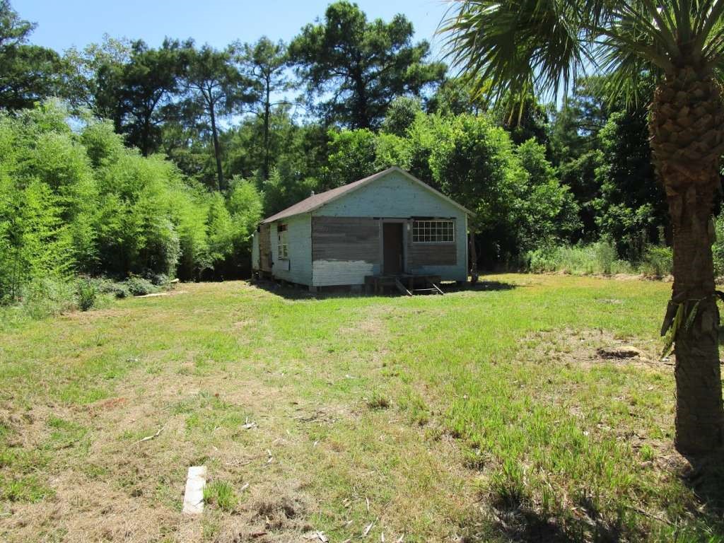 475 County Road 2557 Cleveland, TX 77327 - Photo 1 of 6 a white house that has a tree in the grass