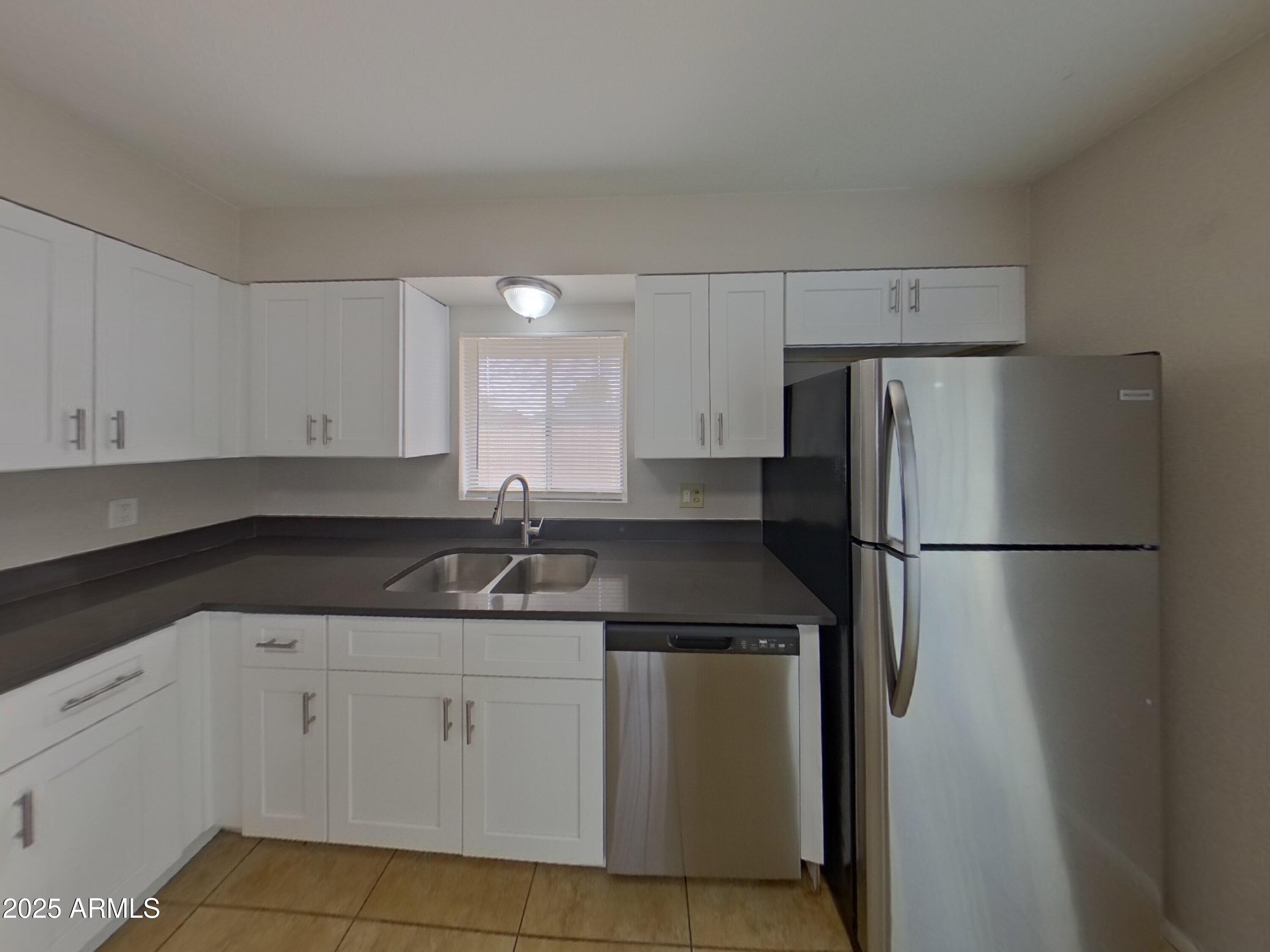 7955 West Montecito Avenue Phoenix, AZ 85033 - Photo 7 of 19 a kitchen with white cabinets and refrigerator