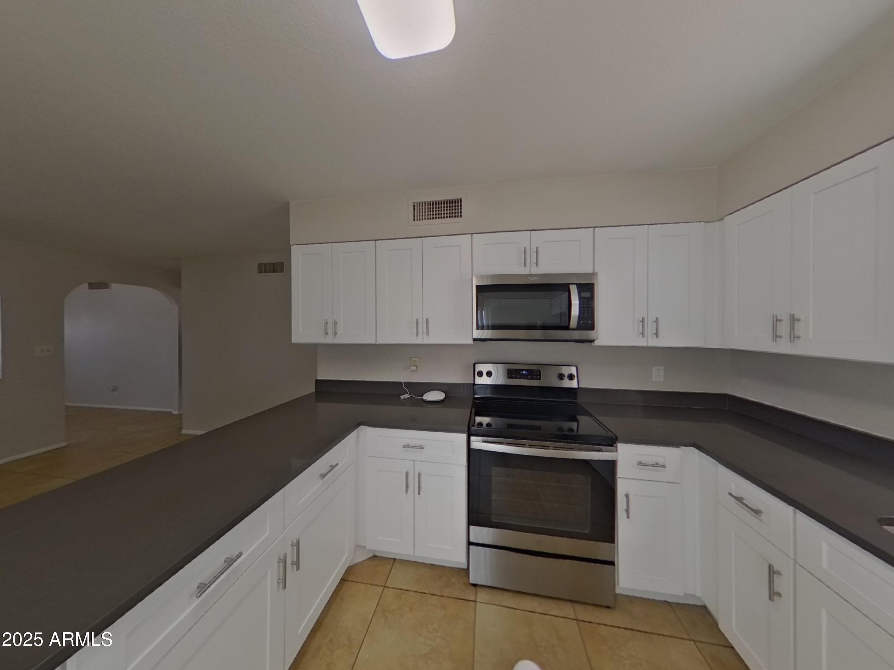 7955 West Montecito Avenue Phoenix, AZ 85033 - Photo 8 of 19 a kitchen with granite countertop white cabinets and stainless steel appliances