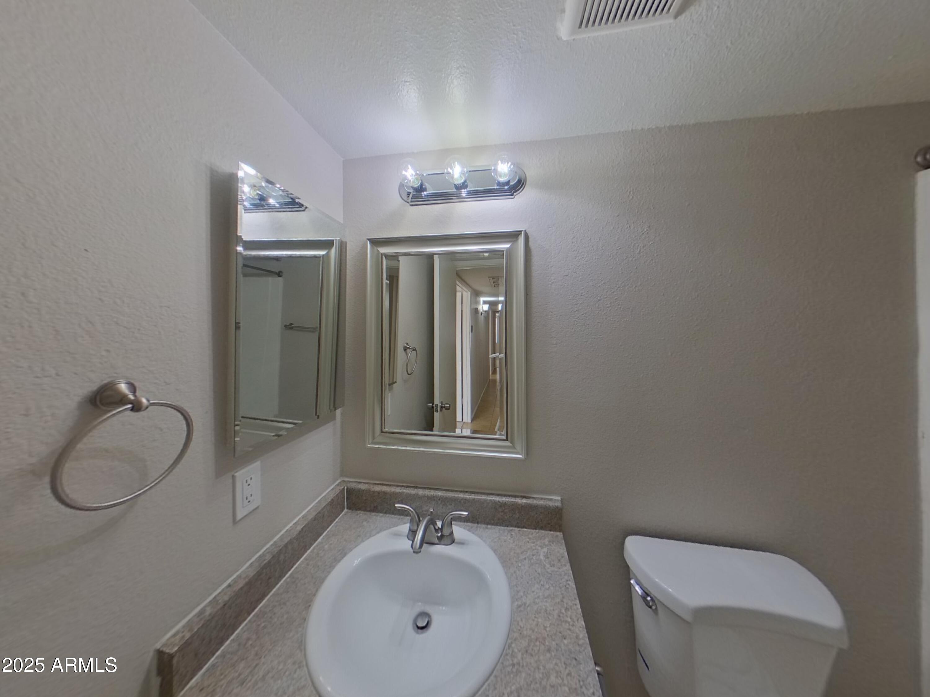7955 West Montecito Avenue Phoenix, AZ 85033 - Photo 13 of 19 a bathroom with a toilet sink vanity granite and shower