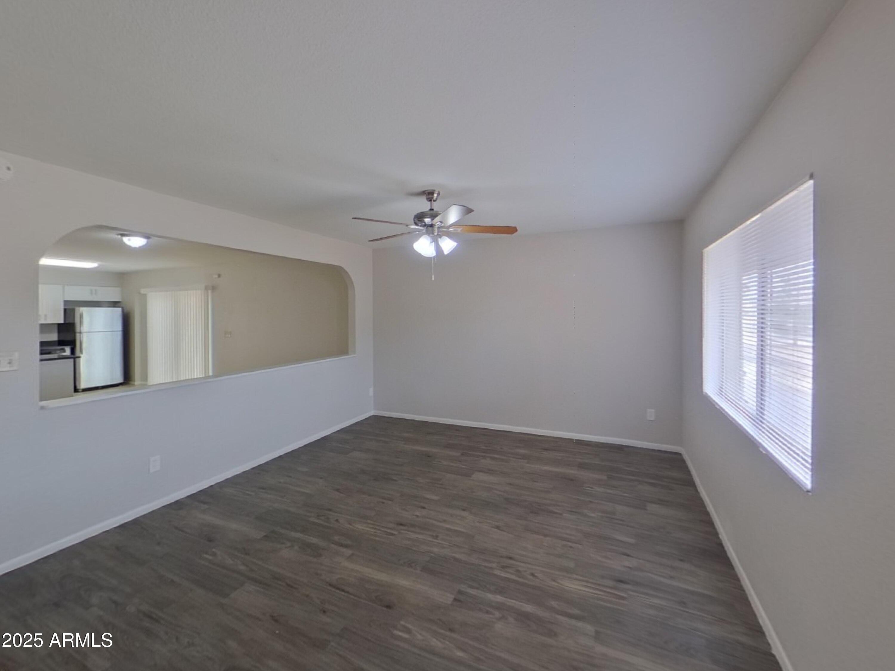 7955 West Montecito Avenue Phoenix, AZ 85033 - Photo 3 of 19 a view of an empty room with wooden floor and a window