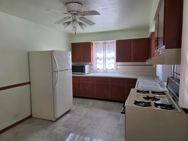 a kitchen with stainless steel appliances granite countertop a refrigerator a sink a stove a microwave a counter top and cabinets