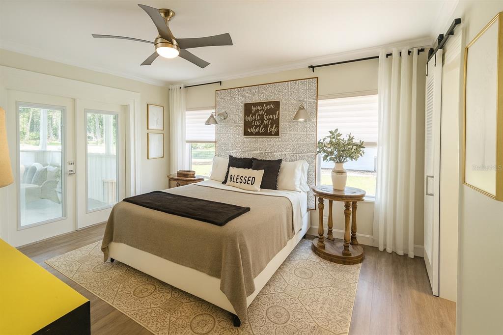 21135 Peckham Avenue Mount Dora, FL 32757 - Photo 11 of 39 a bedroom with a bed lamp and a large window