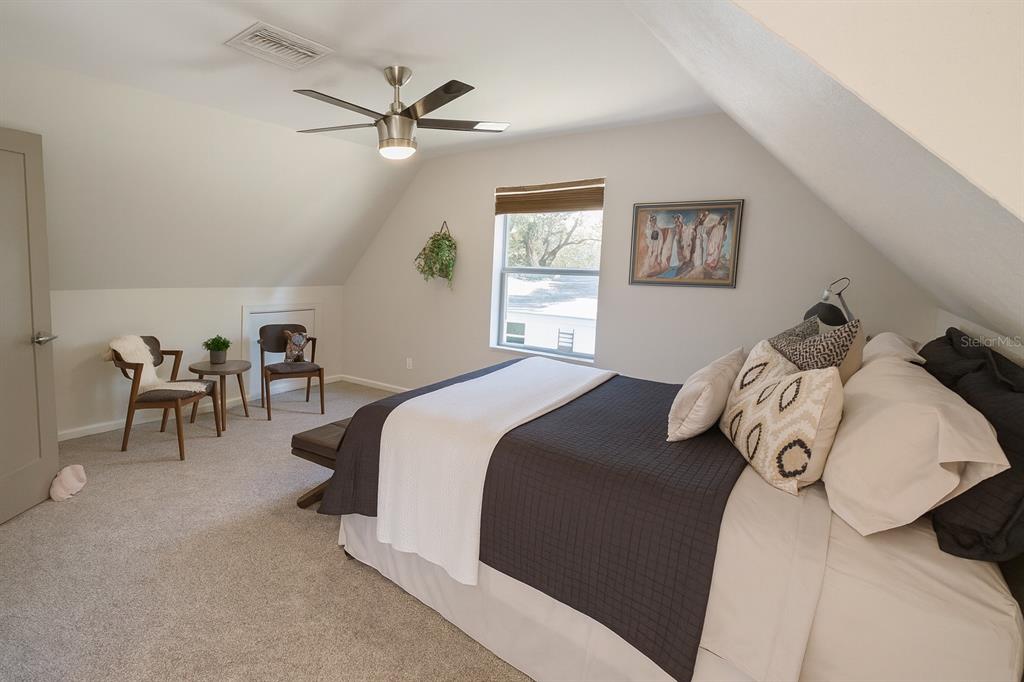 21135 Peckham Avenue Mount Dora, FL 32757 - Photo 15 of 39 a bedroom with bed and a chandelier