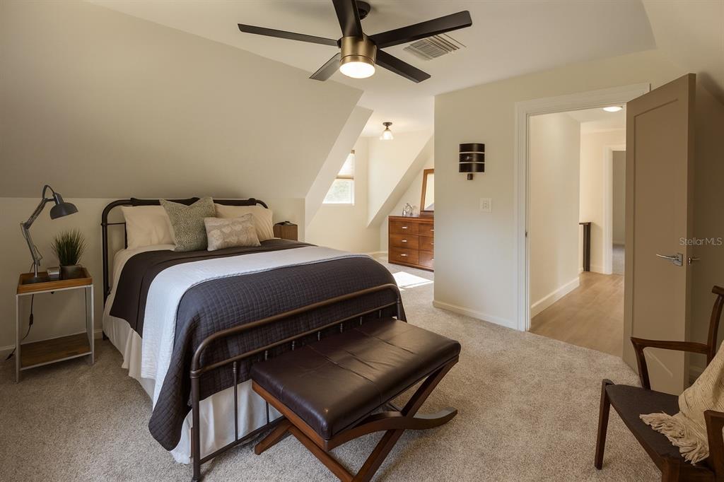 21135 Peckham Avenue Mount Dora, FL 32757 - Photo 16 of 39 a bedroom with a bed and a chandelier