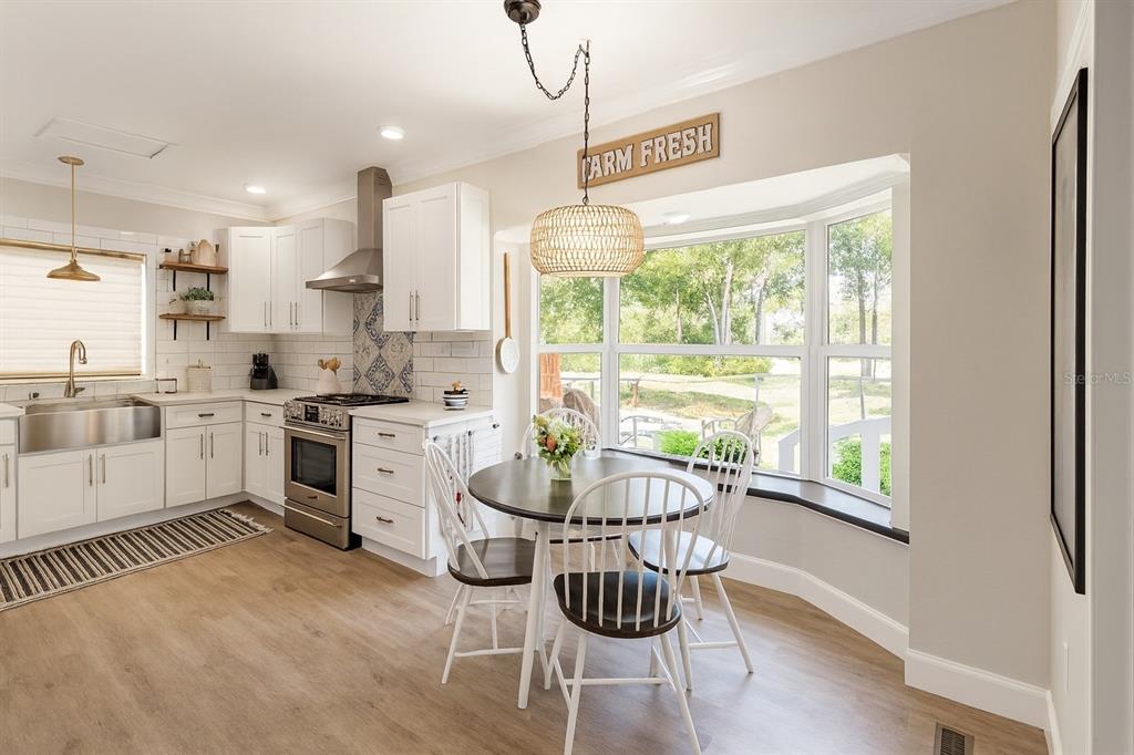 21135 Peckham Avenue Mount Dora, FL 32757 - Photo 5 of 39 a kitchen with a stove a white table and chairs