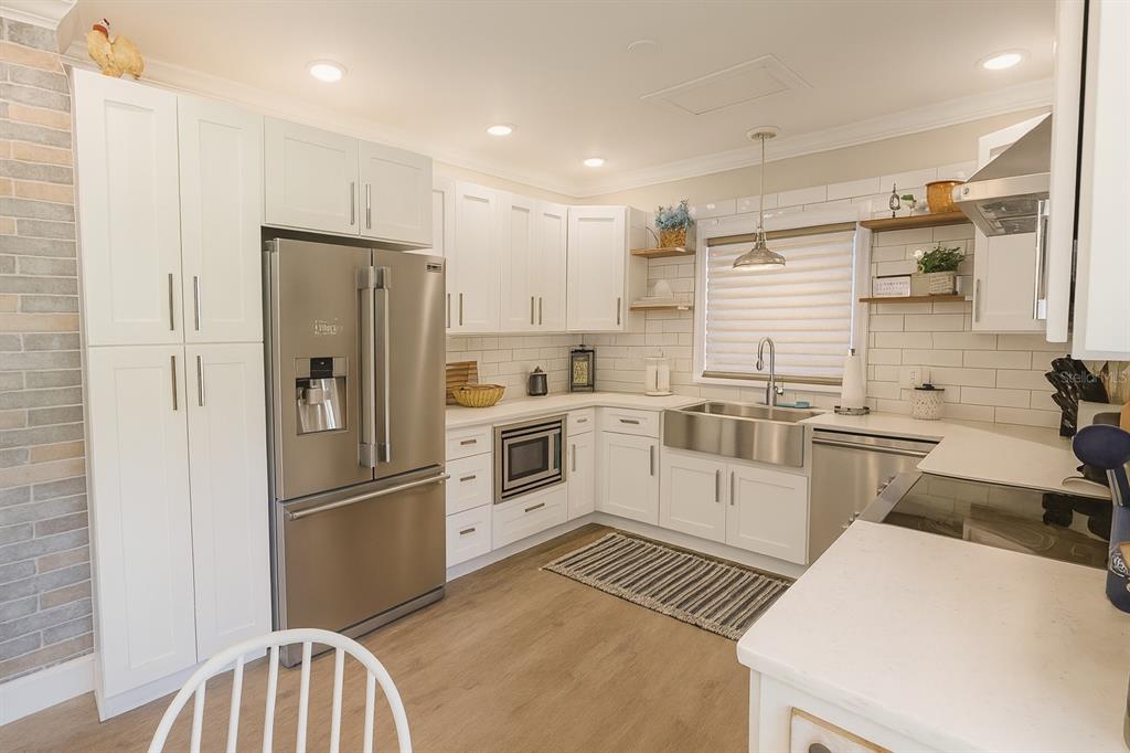 21135 Peckham Avenue Mount Dora, FL 32757 - Photo 6 of 39 a kitchen with a refrigerator a sink and a stove top oven