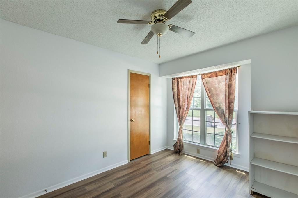 1936 Post Oak Drive Waco, TX 76705 - Photo 13 of 33 Unfurnished room with a textured ceiling, dark wood-style flooring, and ceiling fan
