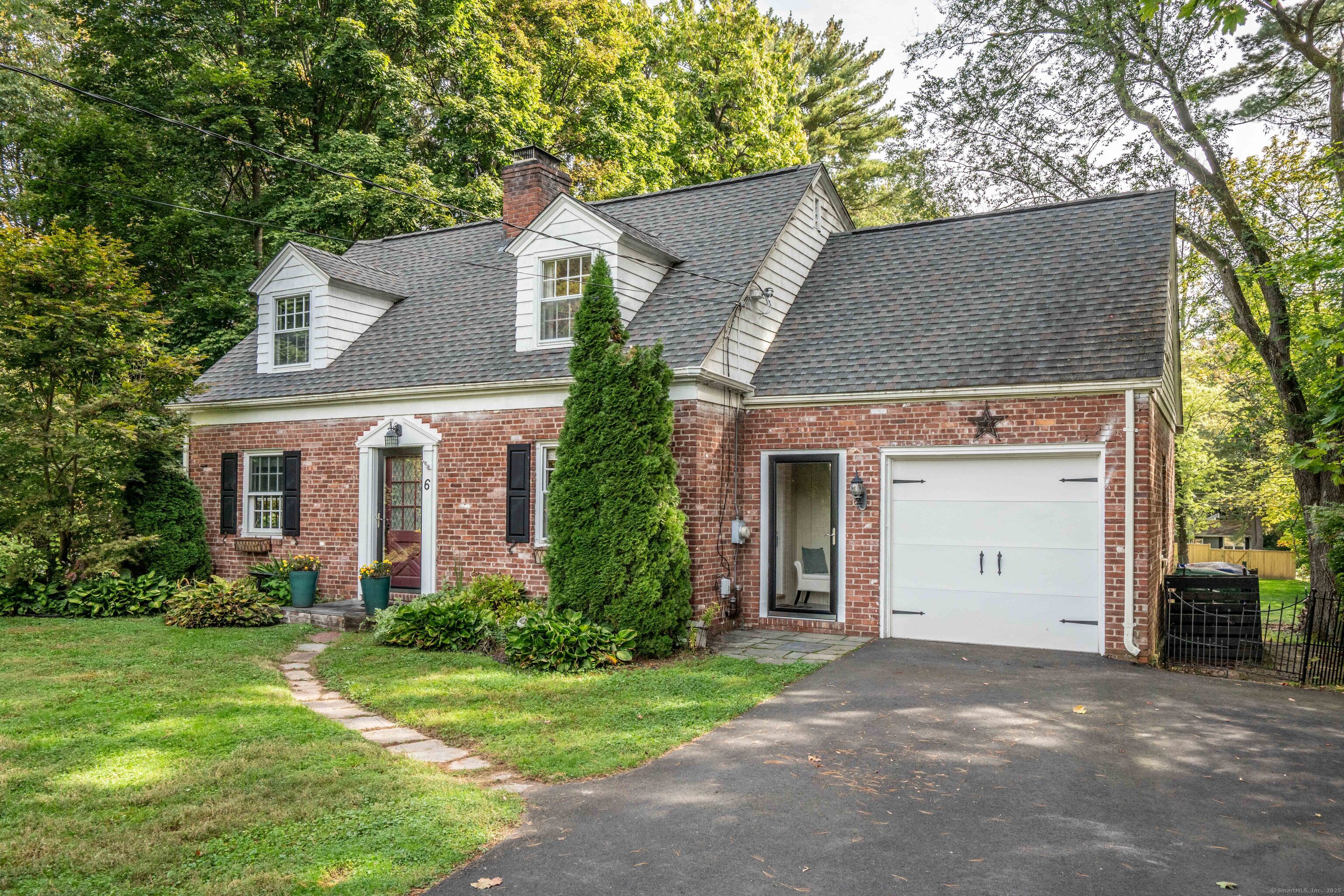 front view of a house with a yard and an trees