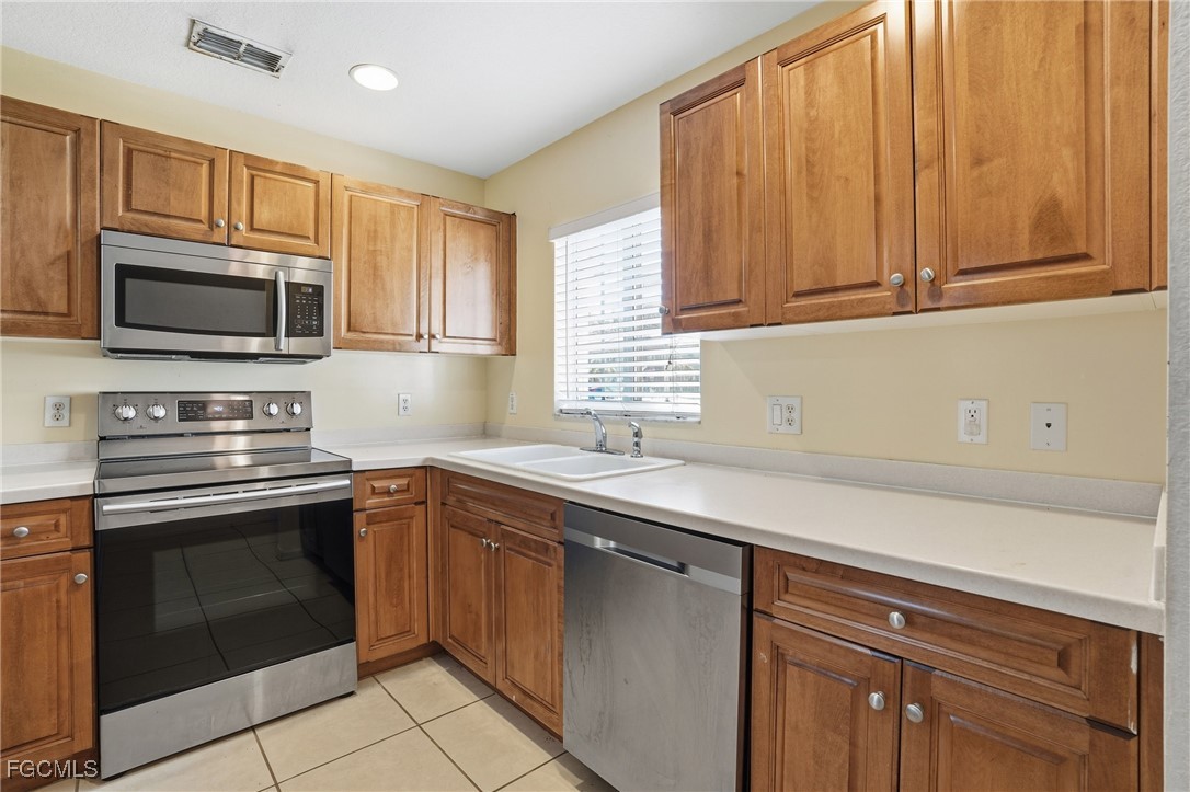 9409 Ivy Brook Run, Unit 1306 Fort Myers, FL 33913 - Photo 11 of 43 a kitchen with a sink stove and microwave
