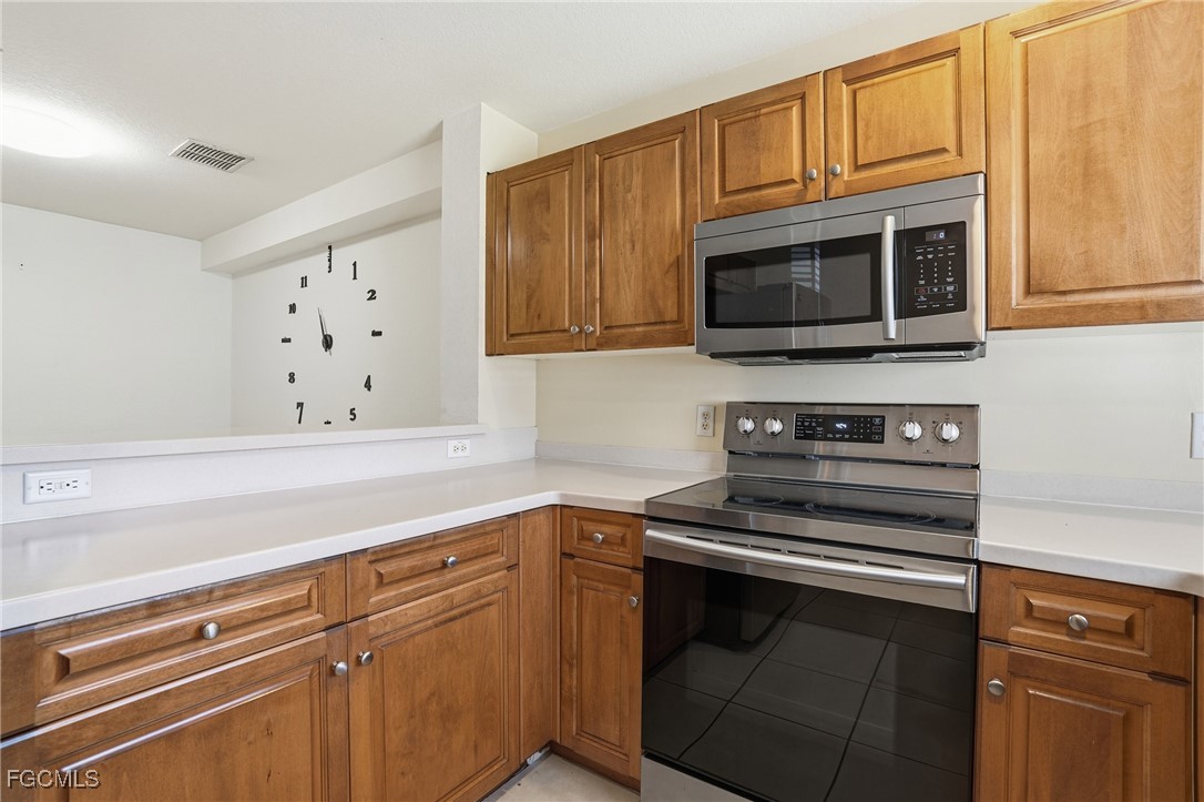 9409 Ivy Brook Run, Unit 1306 Fort Myers, FL 33913 - Photo 12 of 43 a kitchen with cabinets microwave and stove top oven