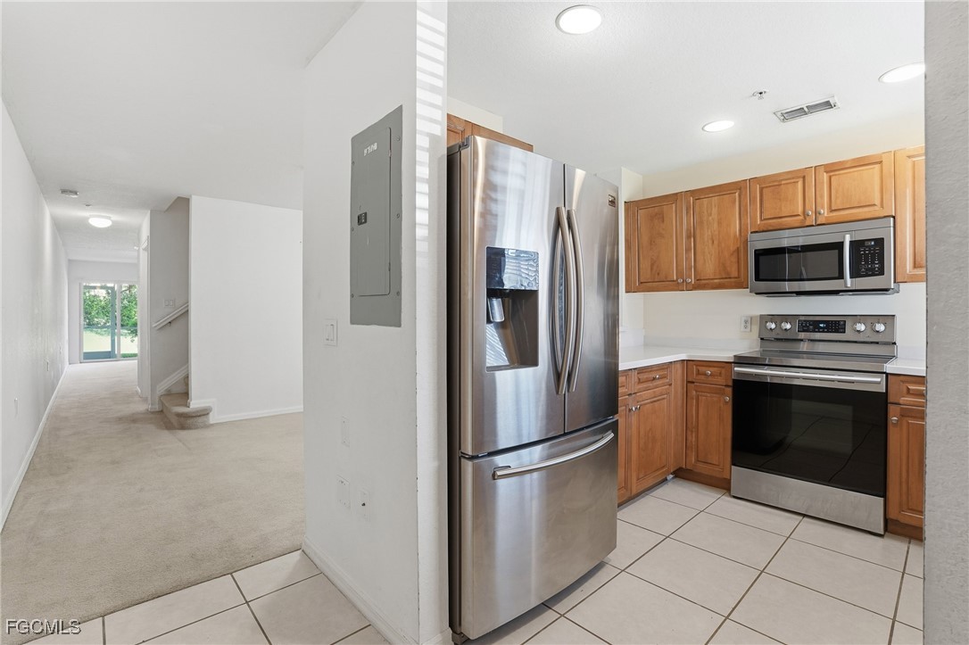 9409 Ivy Brook Run, Unit 1306 Fort Myers, FL 33913 - Photo 9 of 43 a kitchen with stainless steel appliances granite countertop a refrigerator and a stove top oven