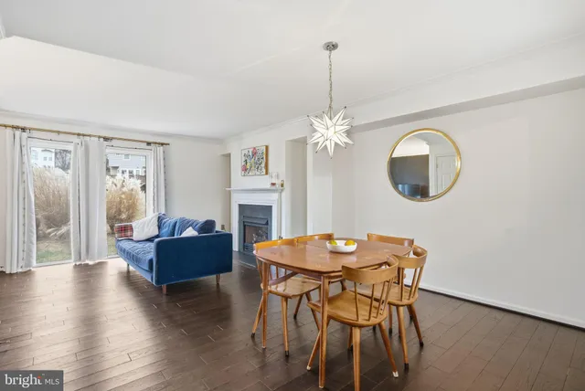 a view of a dining room with furniture a chandelier and wooden floor