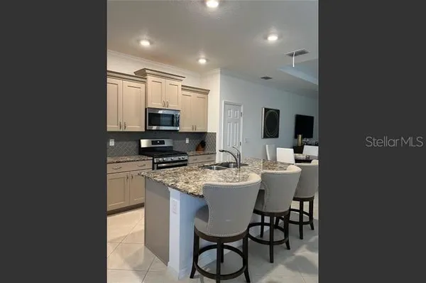 a kitchen with a sink stainless steel appliances and dining table