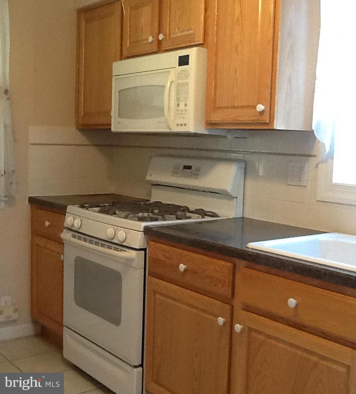 3312 Croydon Road Baltimore, MD 21207 - Photo 11 of 22 a kitchen with granite countertop white cabinets and white appliances