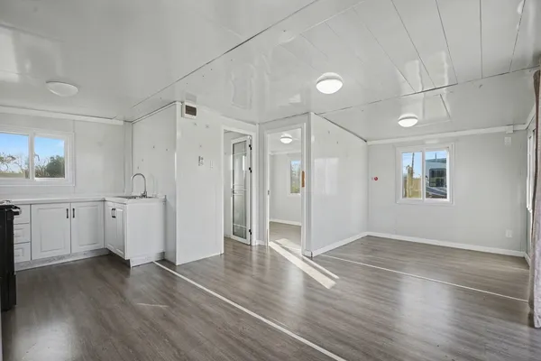 a view of a kitchen with wooden floor and a sink