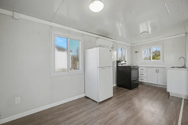 a kitchen with a refrigerator sink and cabinets