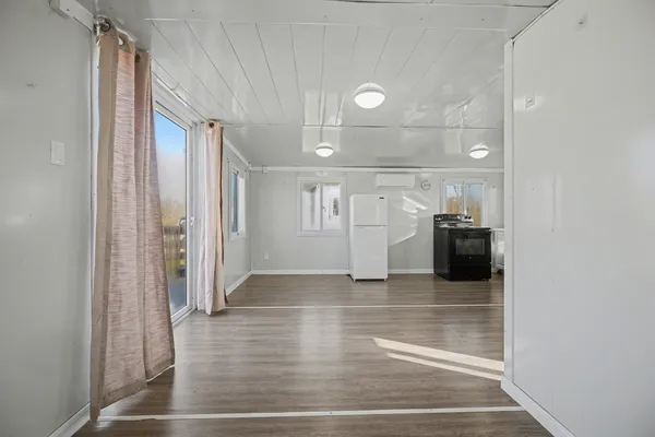 a view of empty room with wooden floor and cabinet