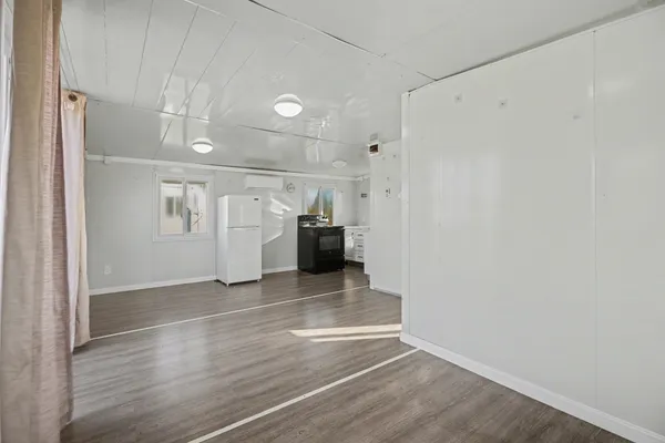 a view of an empty room with wooden floor