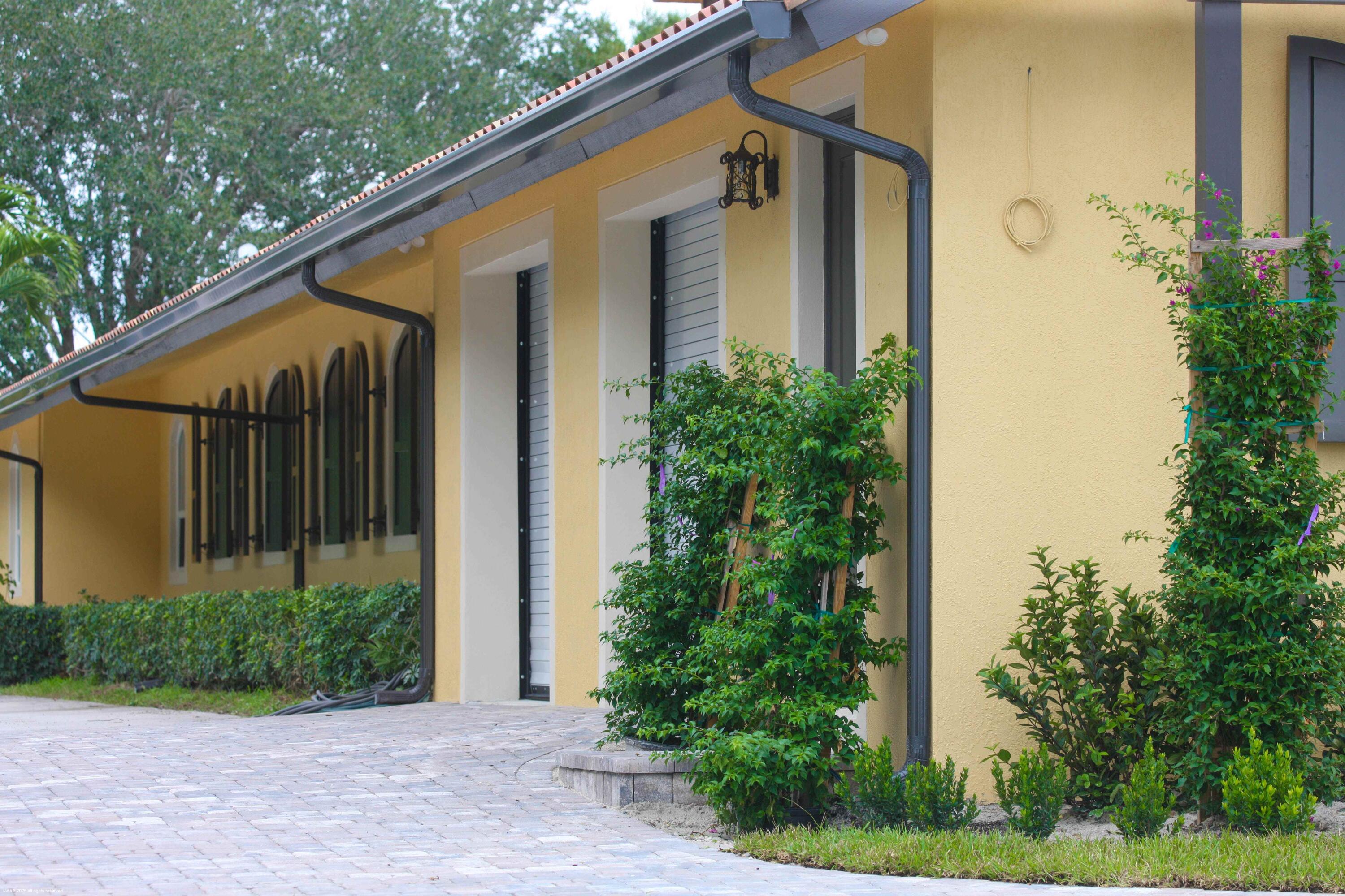 4985 Stables Way Wellington, FL 33414 - Photo 18 of 79 a front view of a house with trees
