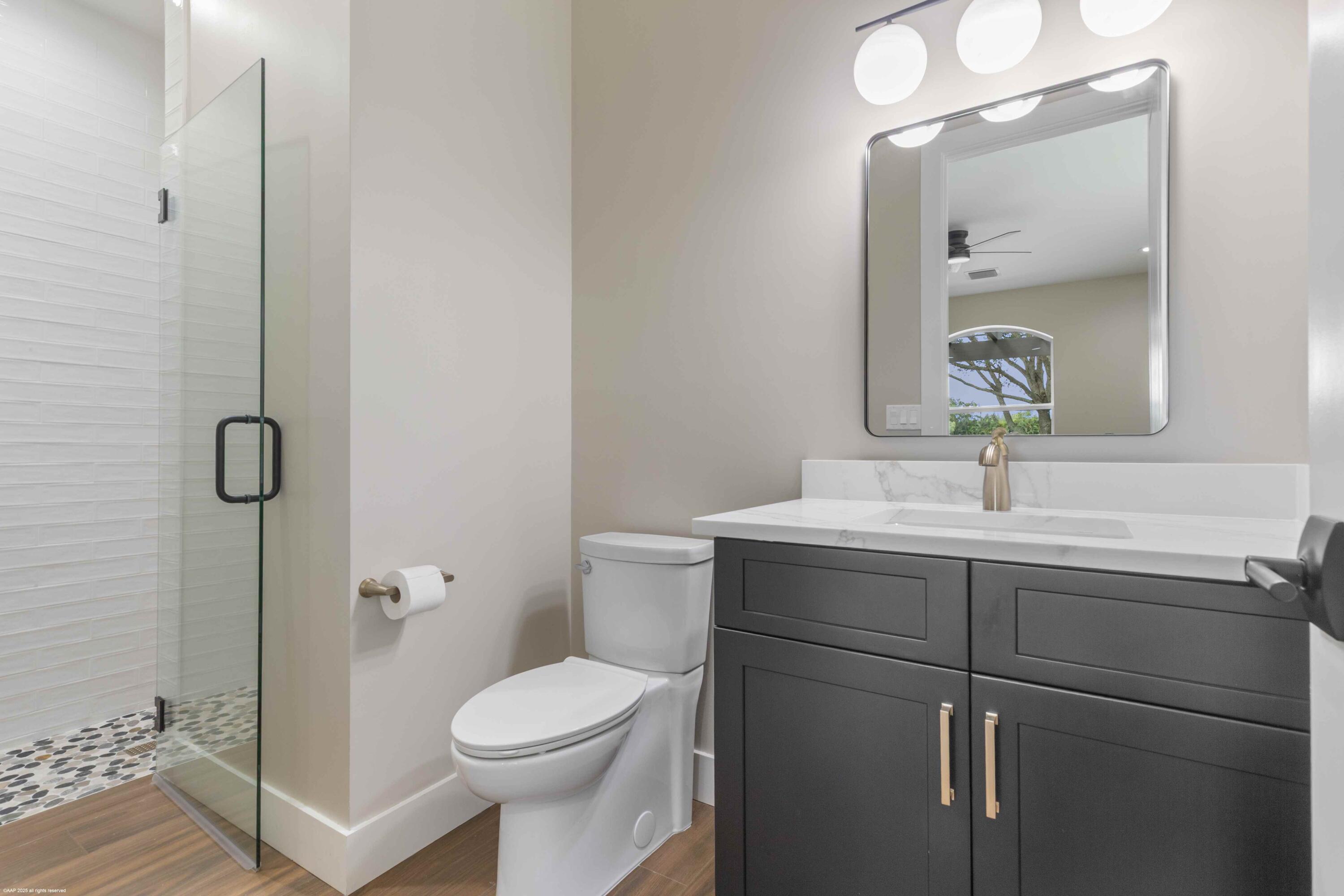 4985 Stables Way Wellington, FL 33414 - Photo 54 of 79 a bathroom with a sink a toilet and shower