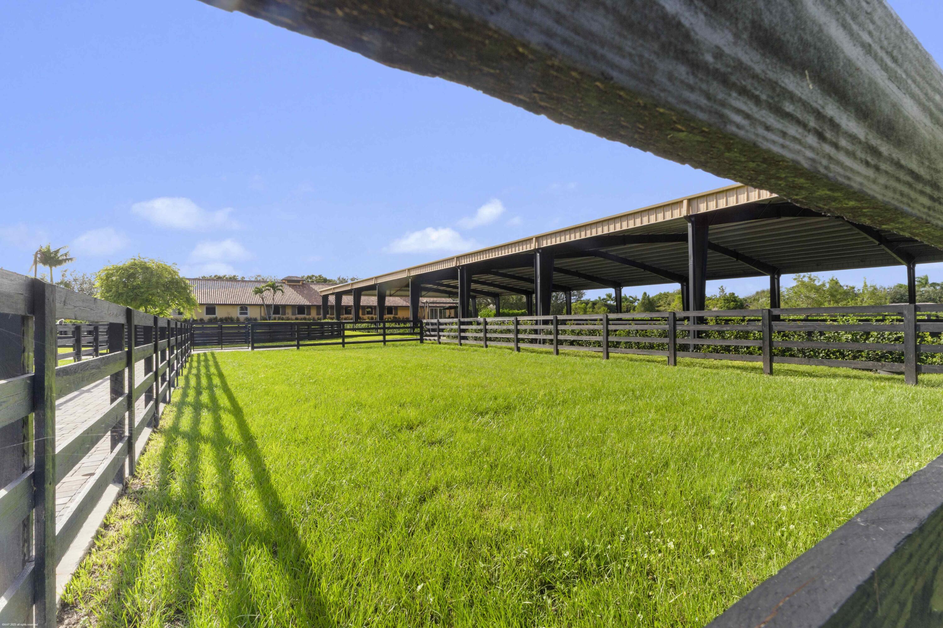 4985 Stables Way Wellington, FL 33414 - Photo 74 of 79 a view of swimming pool with a garden