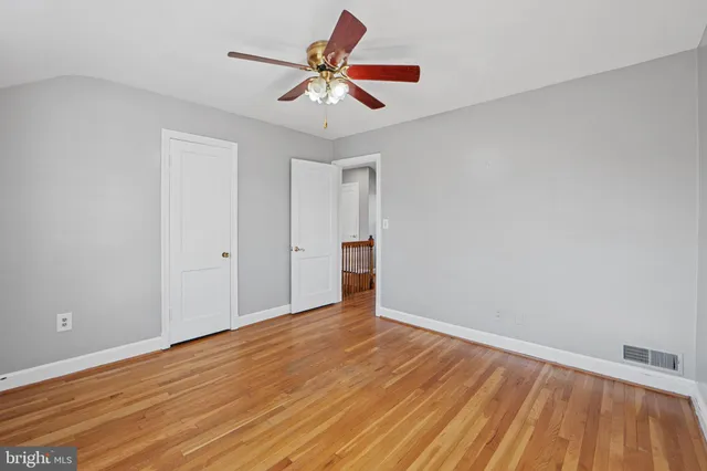 a view of room with wooden floor and ceiling fan
