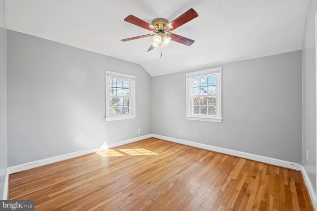 a view of an empty room with window and a chandelier fan