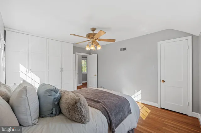 a spacious bedroom with a bed and a chandelier