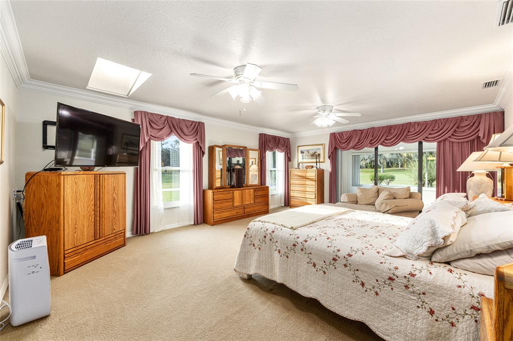 255 Southwest 96th Lane Ocala, FL 34476 - Photo 25 of 87 a bedroom with a large bed and a flat tv screen