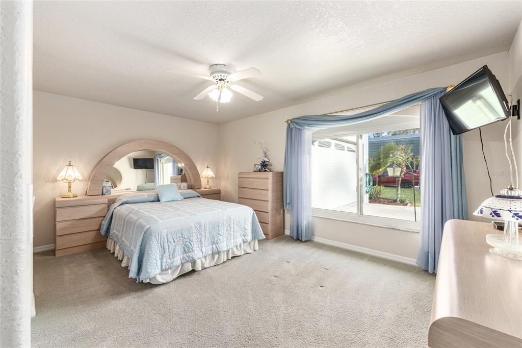 255 Southwest 96th Lane Ocala, FL 34476 - Photo 32 of 87 a spacious bedroom with a large bed and a chandelier