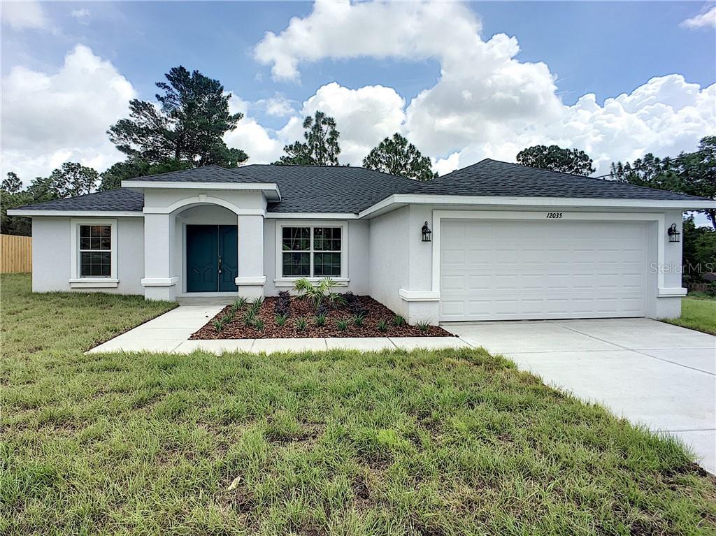 8456 Valmora Street Spring Hill, FL 34608 - Photo 1 of 1 a front view of a house with garden