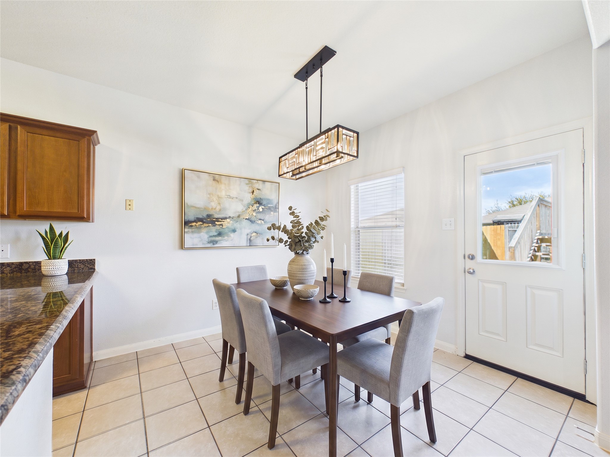 911 Marigold Road Baytown, TX 77521 - Photo 11 of 33 Experience dining in this beautifully virtually staged room, featuring tile flooring, a chic modern light fixture, and a seamless blend of style and comfort.