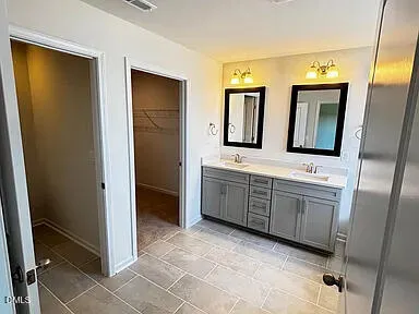 a bathroom with a double vanity sink and a mirror