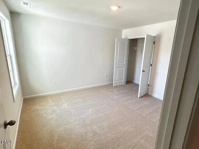 an empty room with closet and mirror