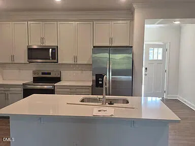 a kitchen with kitchen island a sink stainless steel appliances and cabinets