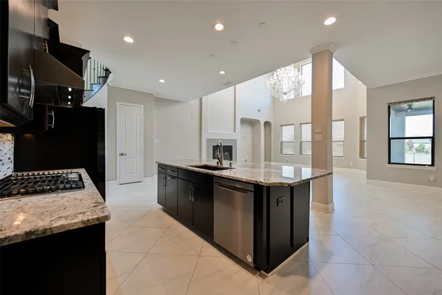 a kitchen with kitchen island granite countertop a stove and a sink