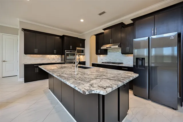 a kitchen with stainless steel appliances granite countertop a counter top a refrigerator and a sink