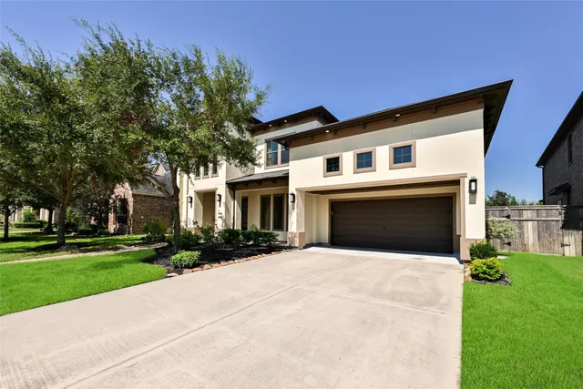 a front view of a house with yard and green space