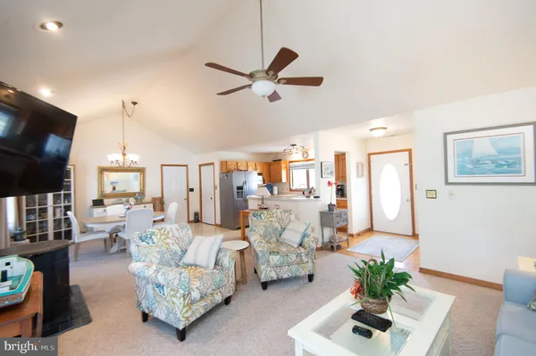 a living room with furniture chandelier and a flat screen tv