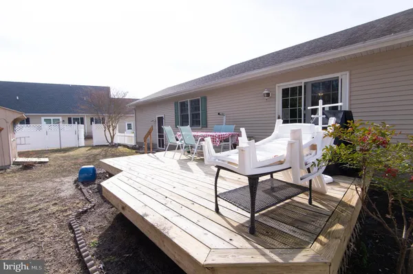 a view of a patio with table and chairs with wooden floor and plants