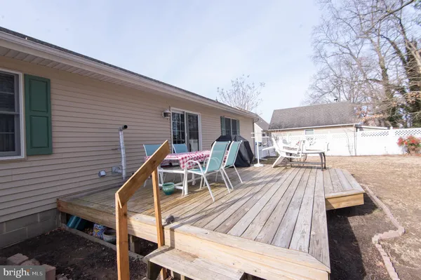 a view of a roof deck with table and chairs with wooden floor and fence